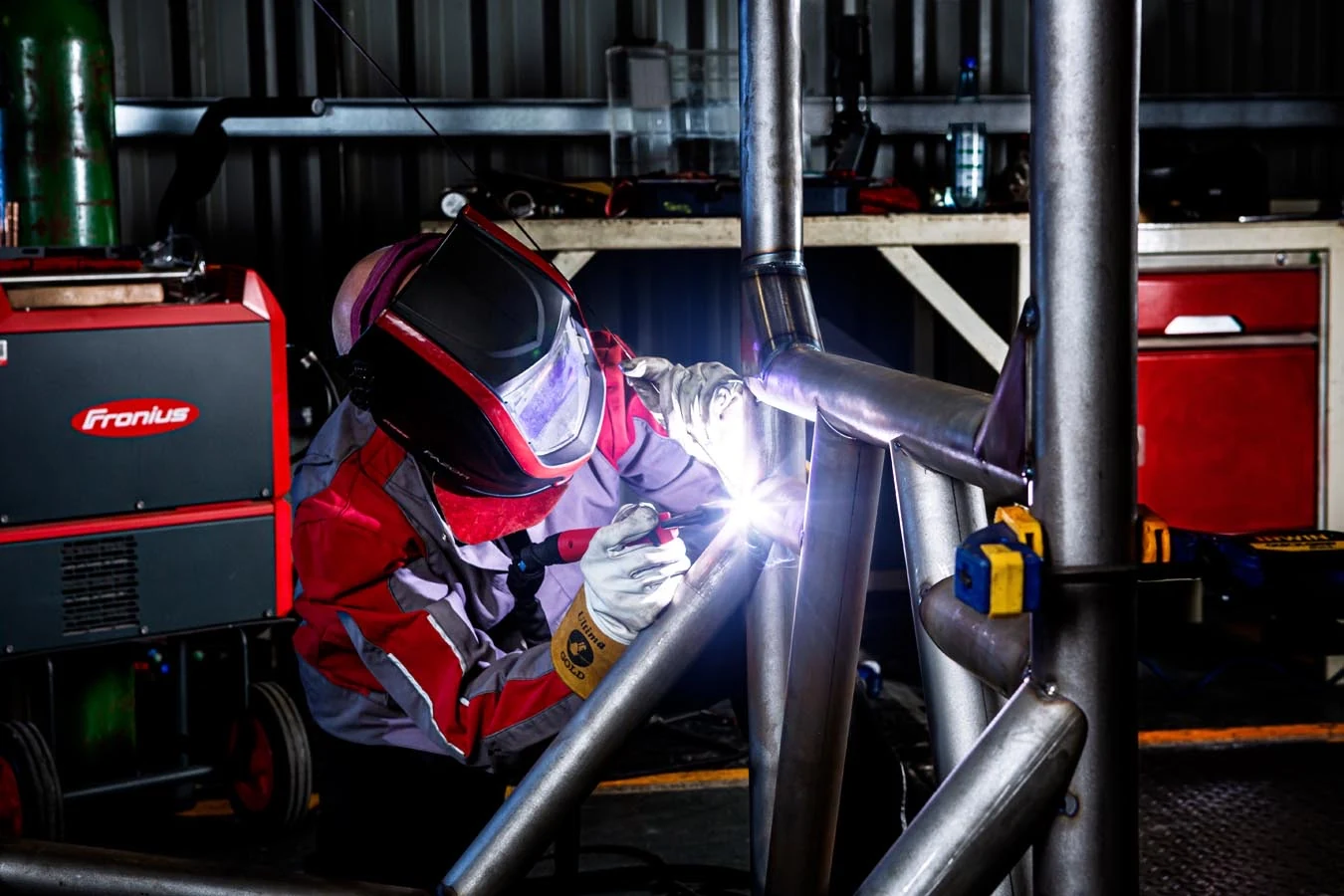 Industrial welder fabricating a metal frame in a workshop