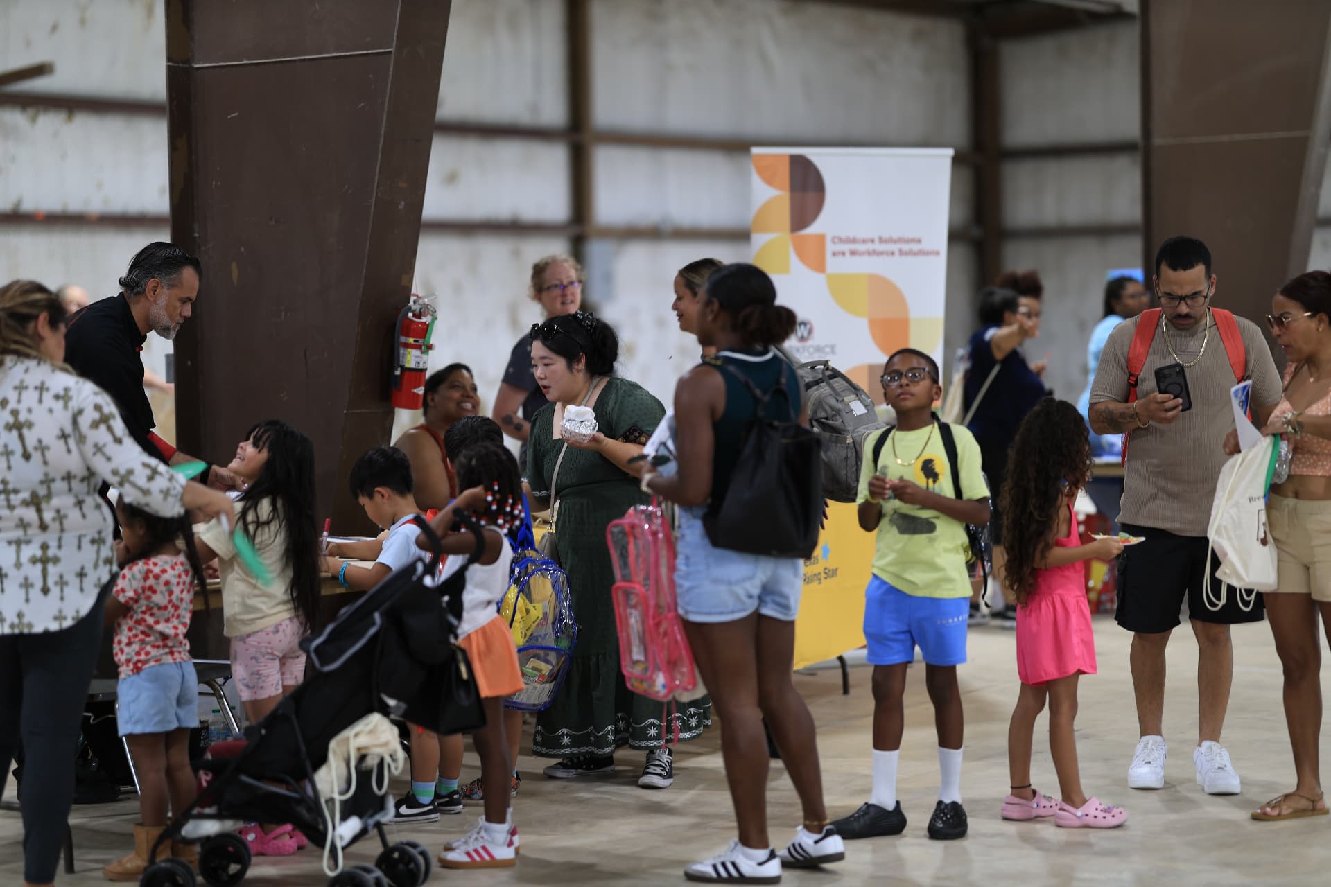 Families visiting vendor booths at a community resource fair, photographed by IVAN