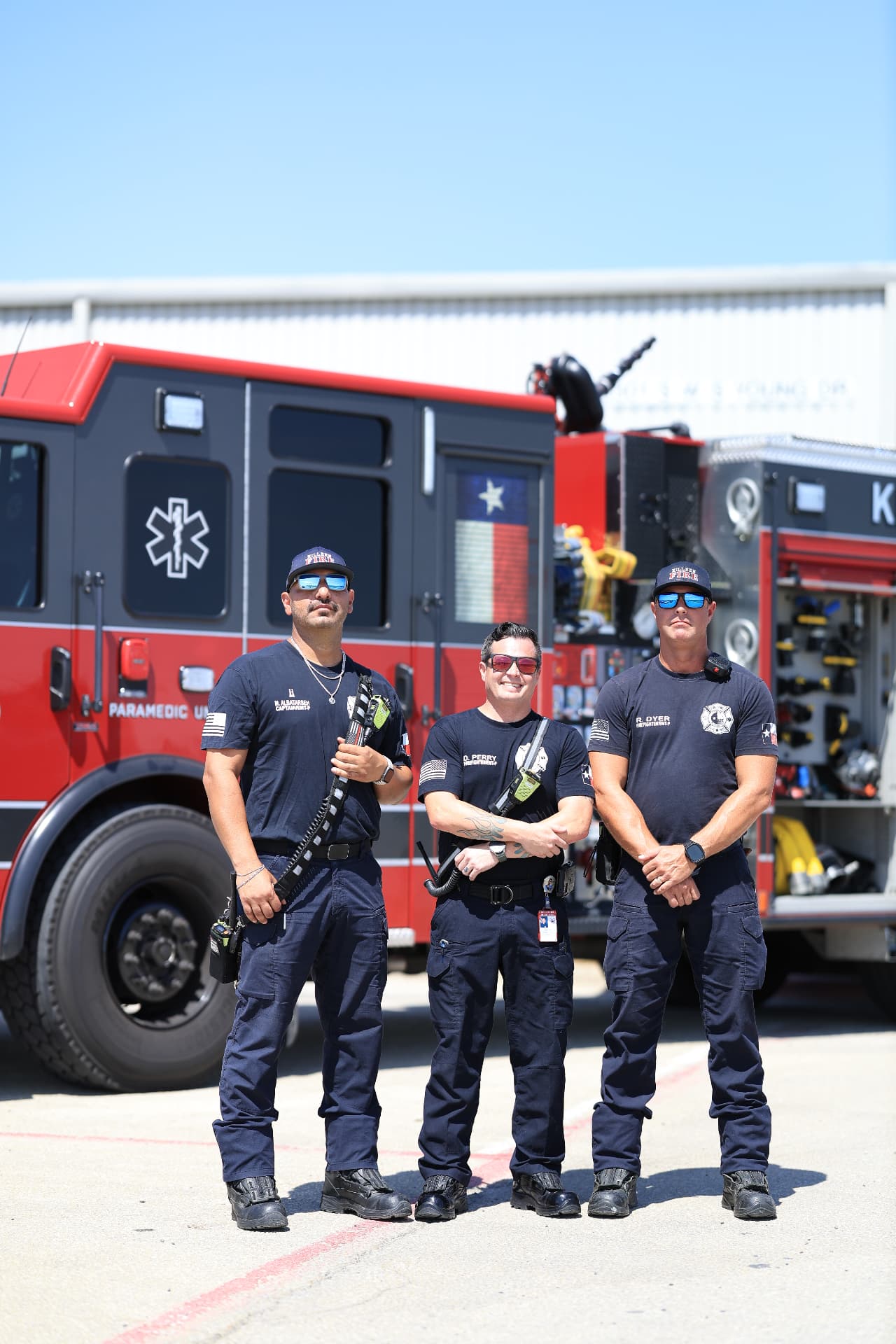 Firefighters posed in front of a fire engine, photographed by IVAN