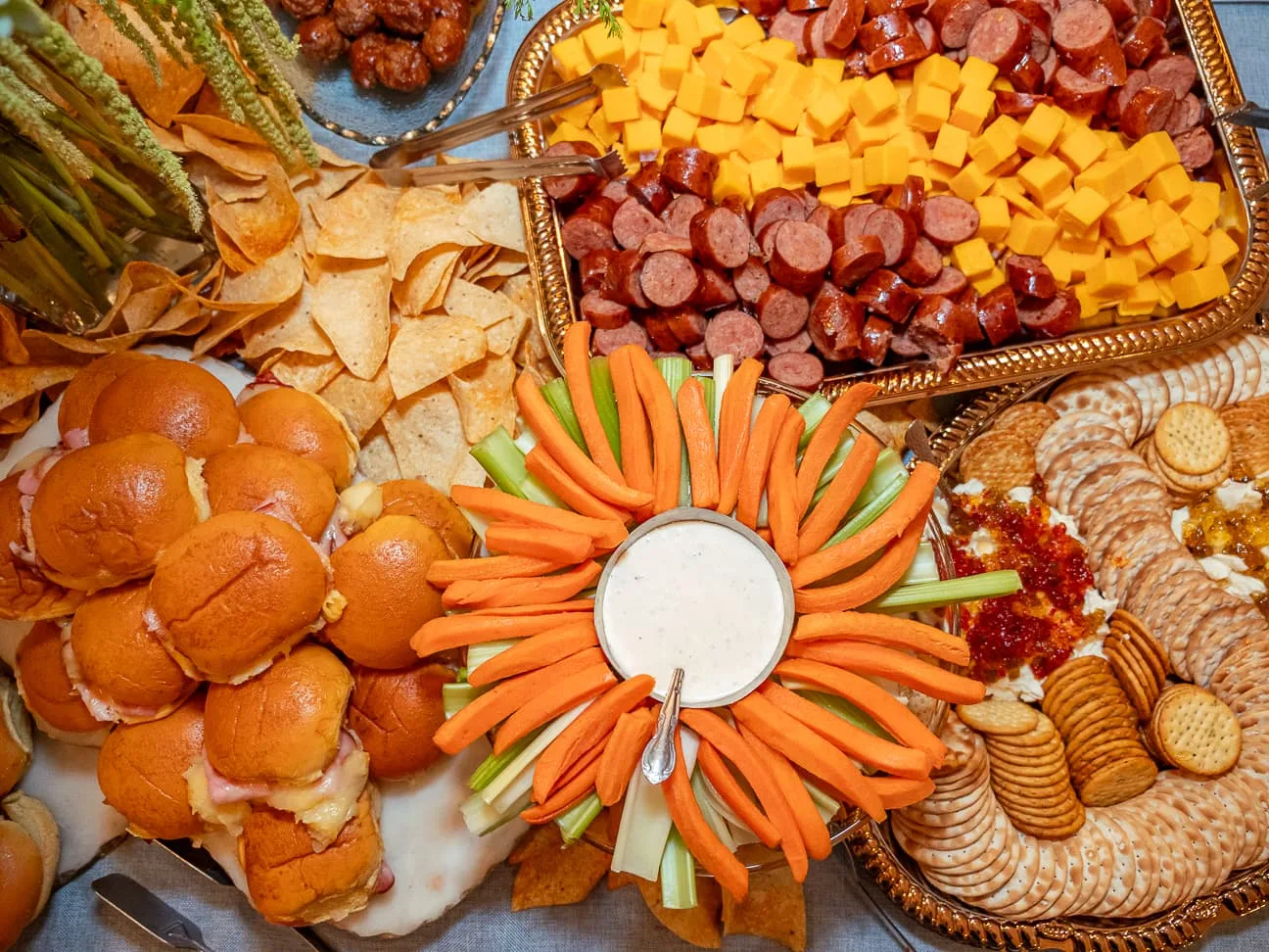 Event catering spread with sliders, cheese, sausage, crackers and a vegetable tray, photographed by John, a Brand With Care creative partner