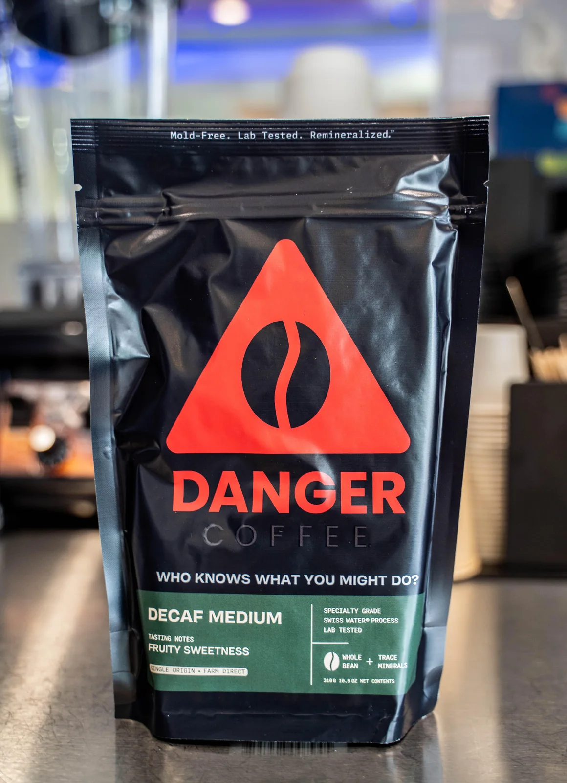 Packaged decaf coffee product photographed on a cafe counter