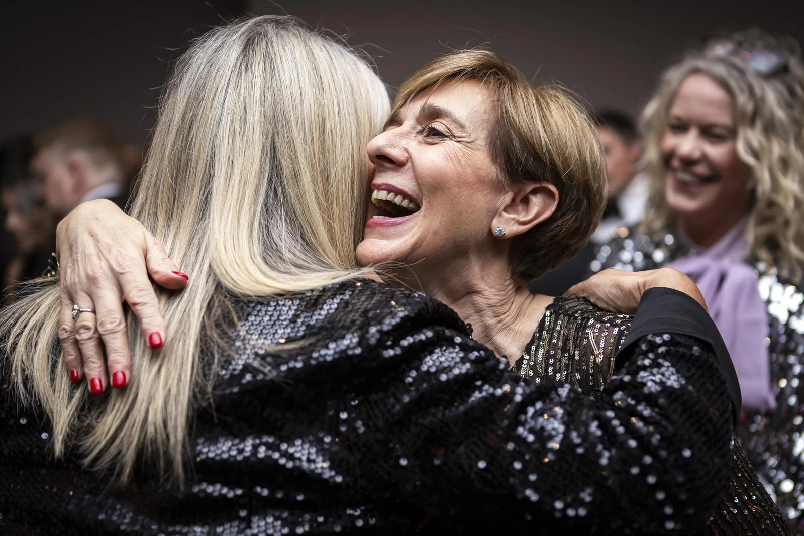 Candid embrace between guests at a formal event photographed by Marcin
