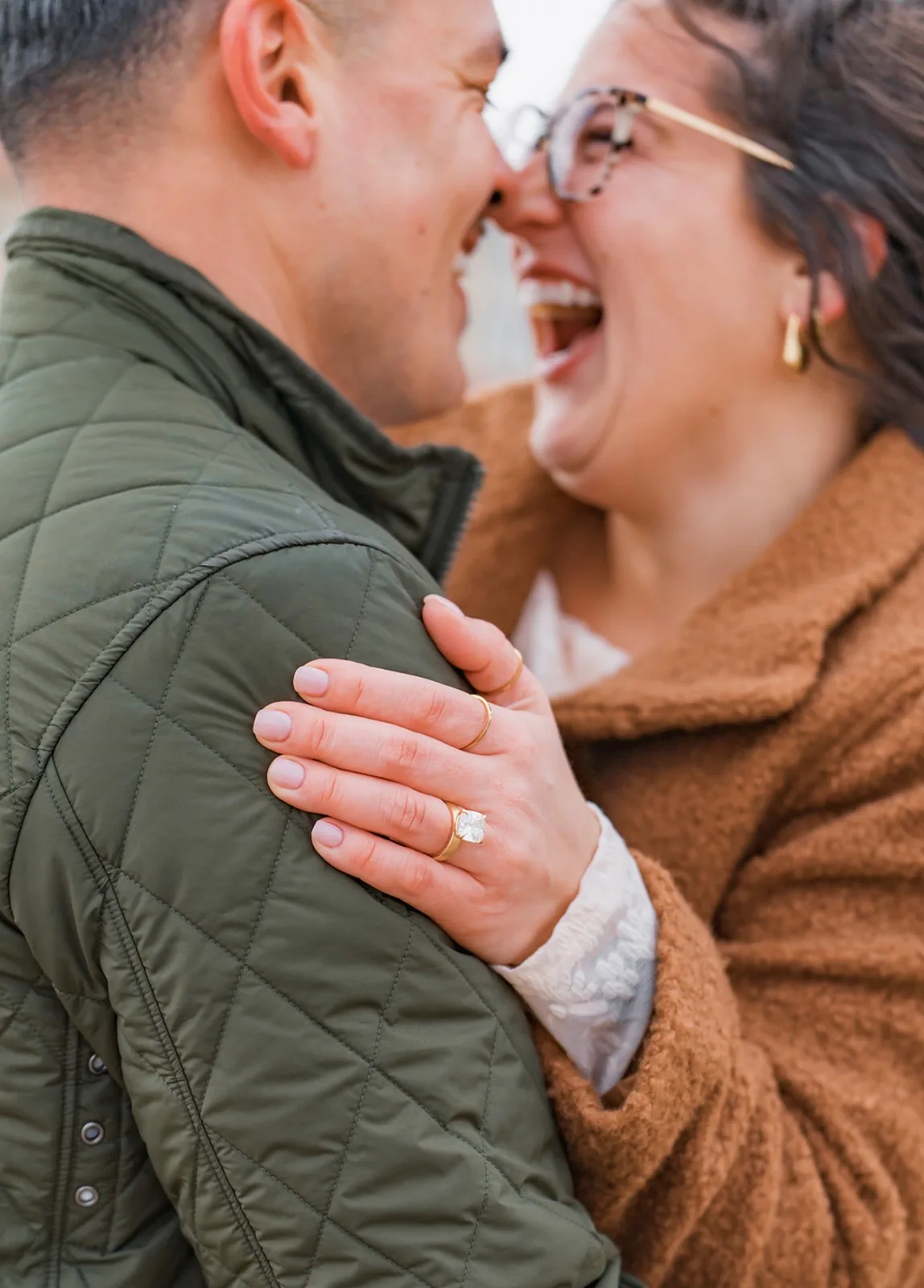 Joyful engagement portrait highlighting a ring photographed by LORENA