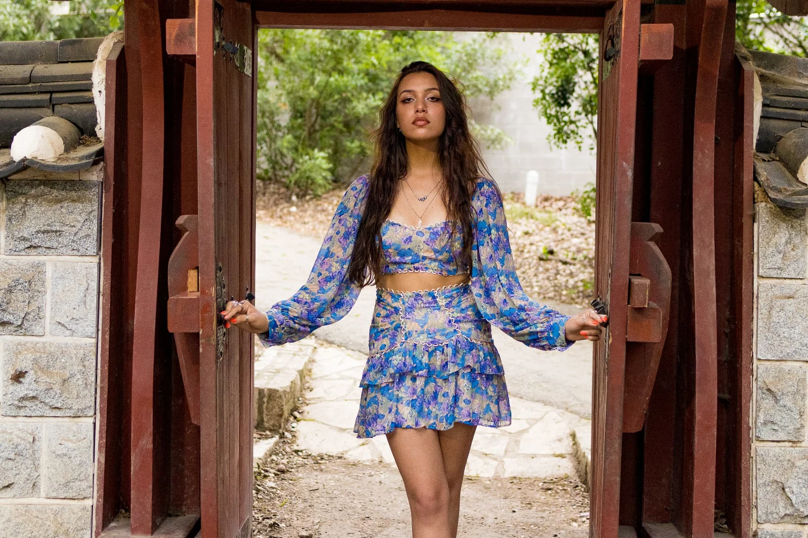 Outdoor fashion portrait framed by a garden gate photographed by Anthony