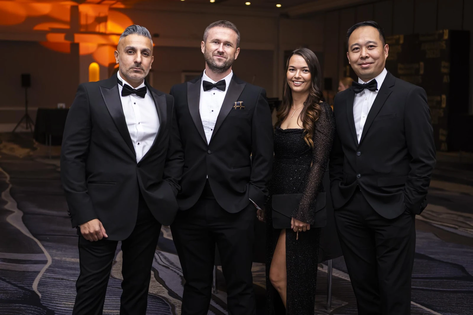 Four guests in formal attire photographed by Marcin at an evening event