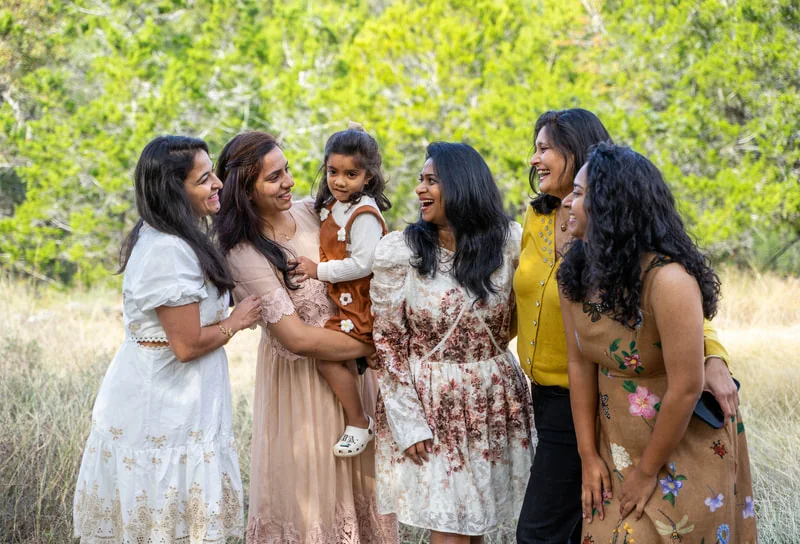 Group of women and a young child sharing a joyful moment outdoors
