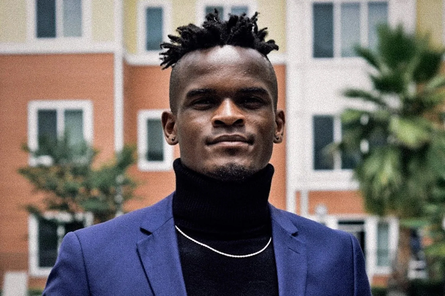 Outdoor portrait of a man in a blue blazer and black turtleneck