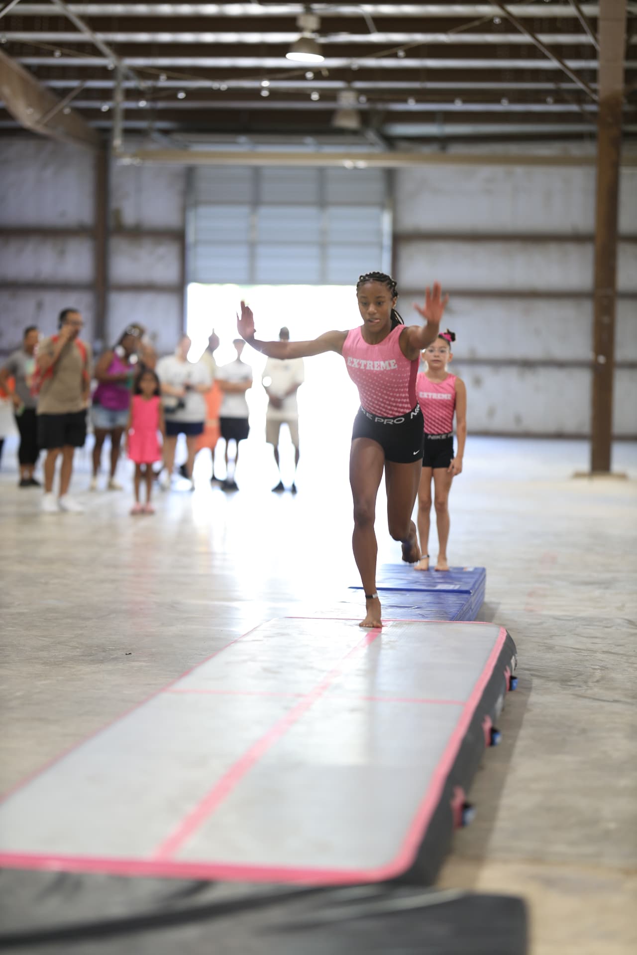 Young gymnast performing a tumbling run at a community festival, photographed by IVAN