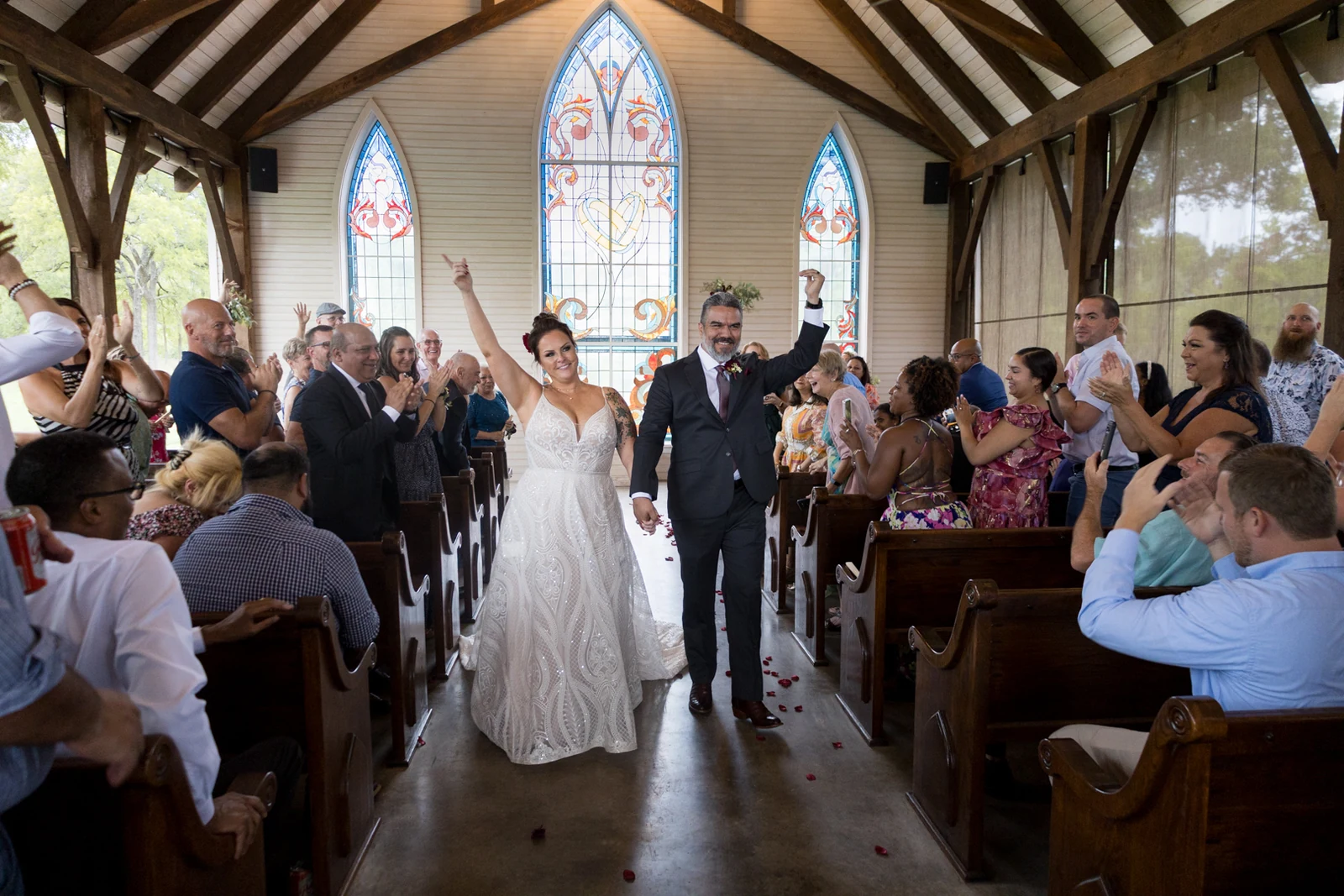 Newlyweds celebrating as they walk through a chapel photographed by Anthony