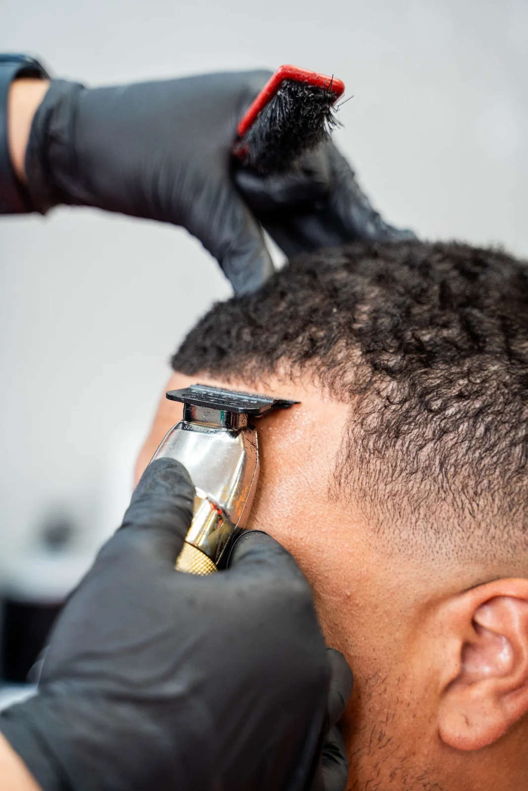 Barber creating a precise haircut detail with professional clippers