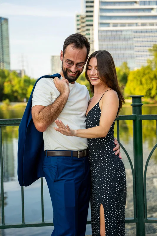 Couple smiling together beside the water during a celebratory portrait session