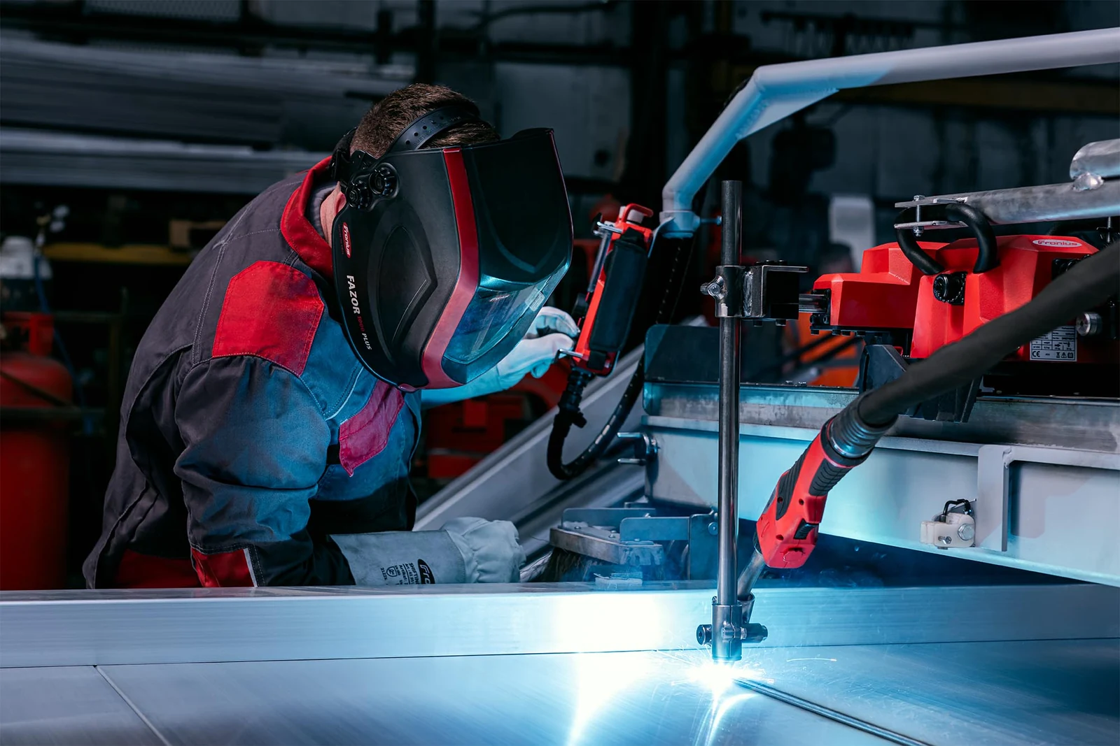 Industrial worker welding metal machinery photographed by Marcin