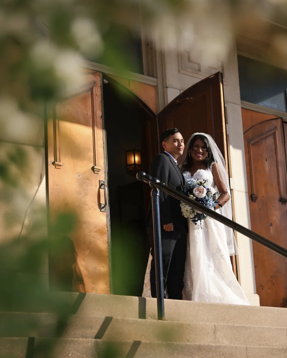 Bride and groom framed in a sunlit chapel doorway after the ceremony