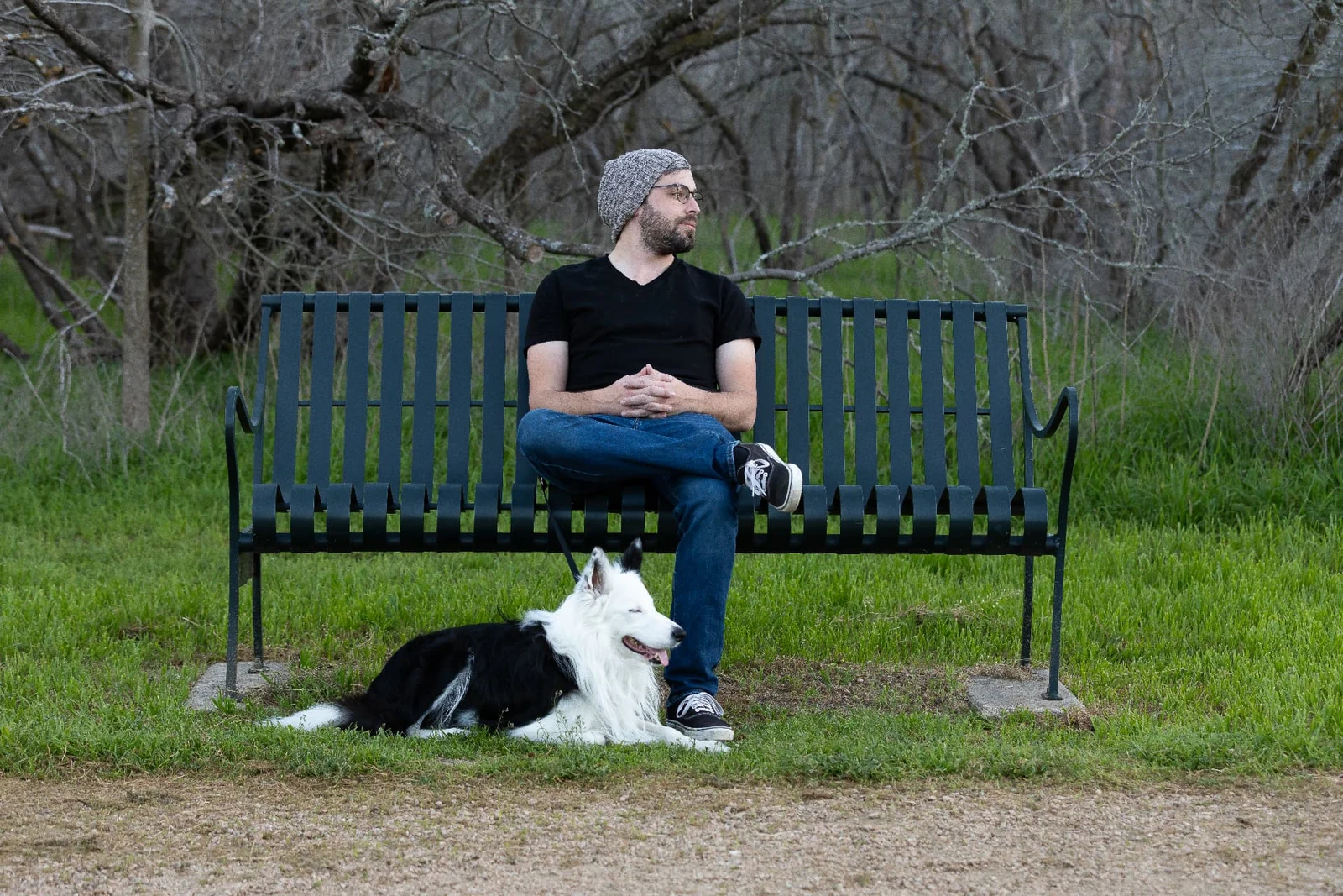 Relaxed outdoor portrait with a dog beside a park bench photographed by Anthony